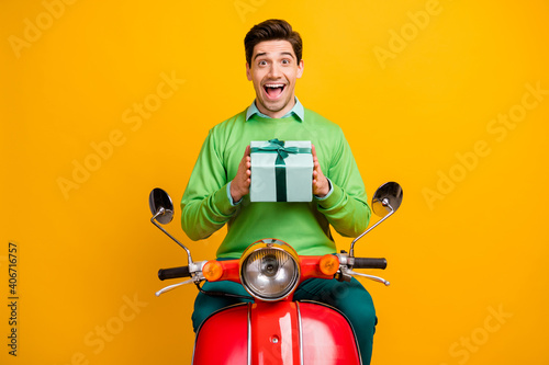 Portrait of impressed handsome guy open mouth hold giftbox unexpected isolated on yellow color background © deagreez