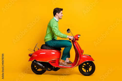 Full size profile photo of person driving moped wear sweater isolated on bright yellow color background © deagreez