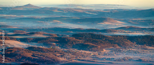 Panorama of a mountain valley shrouded in morning mists seen from the top of the Karkonosze mountain range in Poland