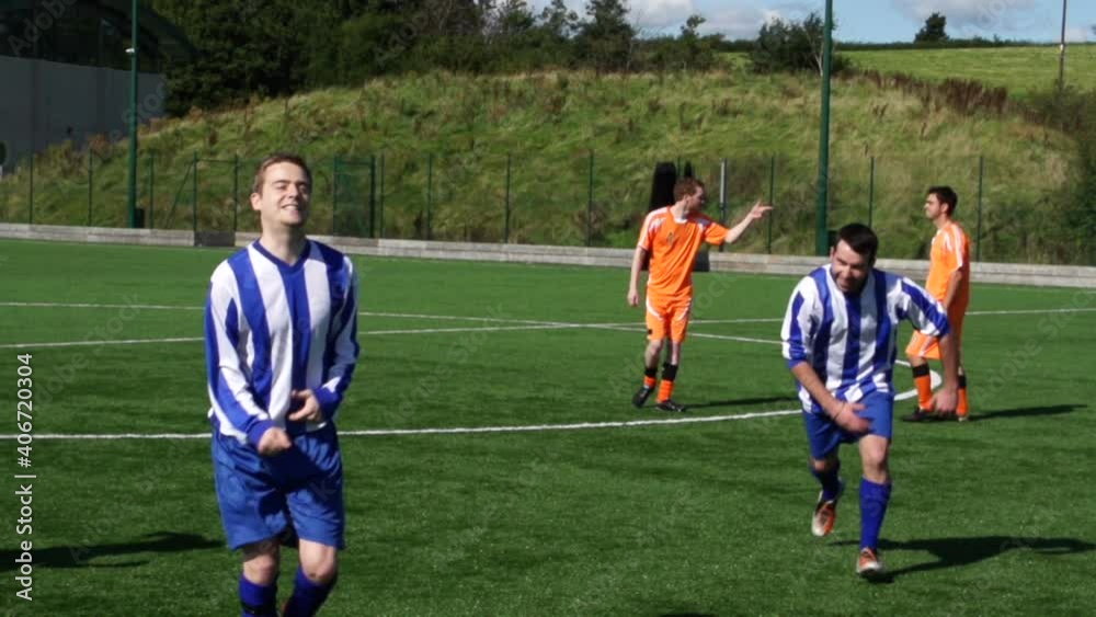 Male Football or Soccer player celebrating scoring a goal in a match with his team mates. Super Slow motion. Stock Video Clip Footage Male Football or Soccer player celebrating scoring a goal in a match with his team mates. Super Slow motion. Stock Video Clip Footage
