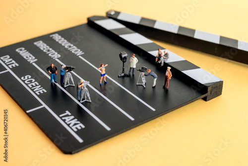 Movie making scene. Crew figurines on a wooden clapper
