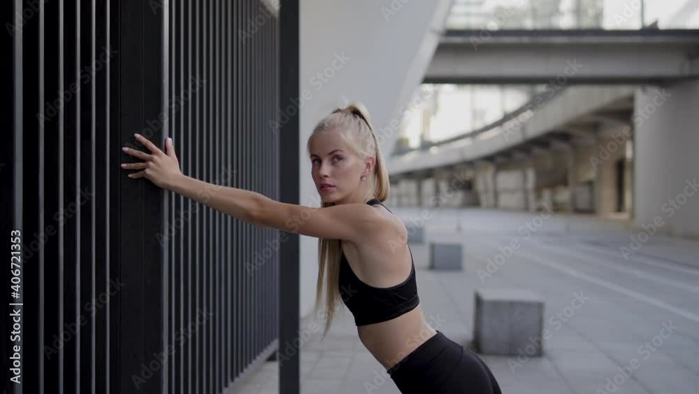 Young sportswoman doing stretching exercises before run, health care, body Young sportswoman doing stretching exercises before run, health care, body
