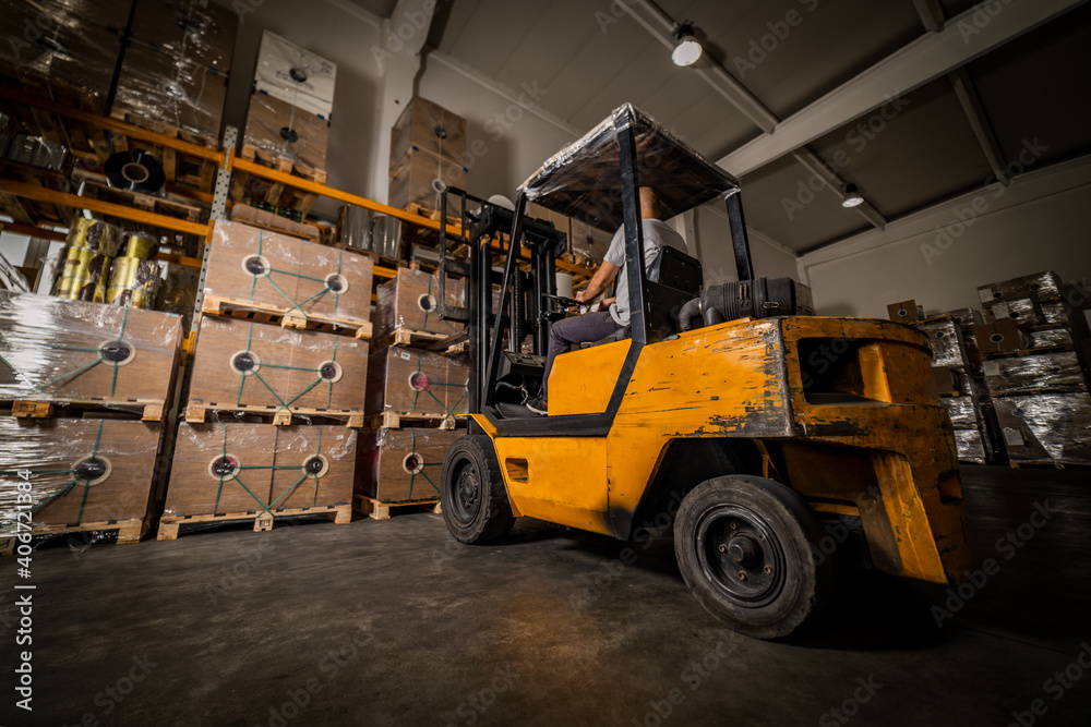 Warehouse man worker with forklift. Warehouse worker driver in loading by forklift stack loader