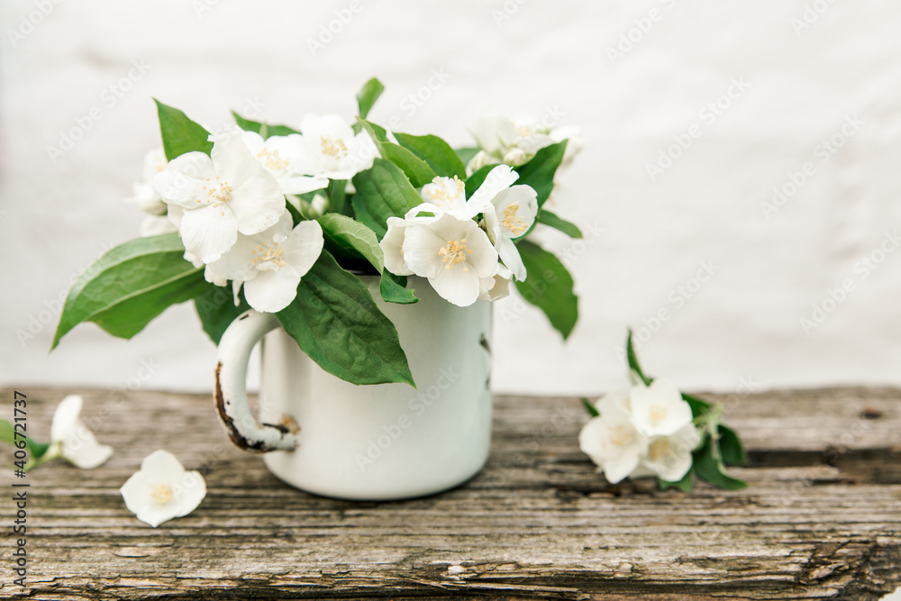 jasmine flowers in rustic metal cup. old rustic wooden background jasmine flowers in rustic metal cup. old rustic wooden background