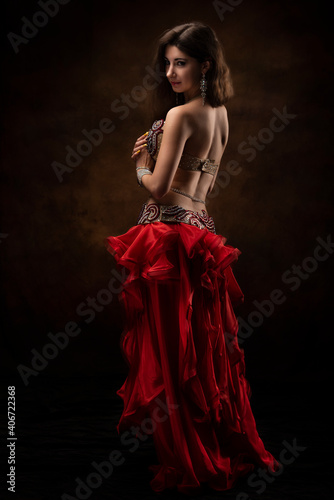 Oriental dancer with a saber. Belly dance. The brunette. Red.
