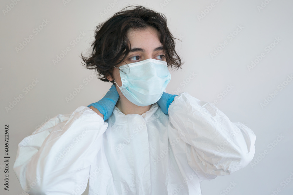 tired, exhausted, overwhelmed healthcare worker nurse doctor. Wearing a medical face mask, gloves, protective coverall. coronavirus pandemic concept covid-19, health professional. 2021 vaccination.