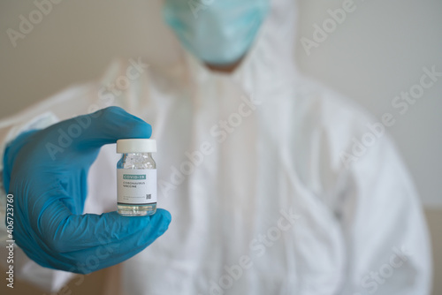healthcare worker nurse, doctor wearing a medical face mask gloves protective coverall holding hand vaccine bottle tube Coronavirus vaccination choice, acceptance of vaccinate covid-19 concept 2021