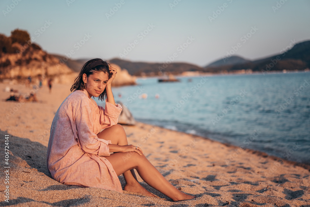 Young beautiful woman having fun at beach. Summer photo of young beautiful girl. Female on beach enjoying sea vacation traveling