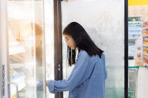 Young woman looking at product at grocery store. female shopping in supermarket and reading product information. Customer buying food at the market. Free Download Young woman looking at product at grocery store. female shopping in supermarket and reading product information. Customer buying food at the market. - GFXLoad