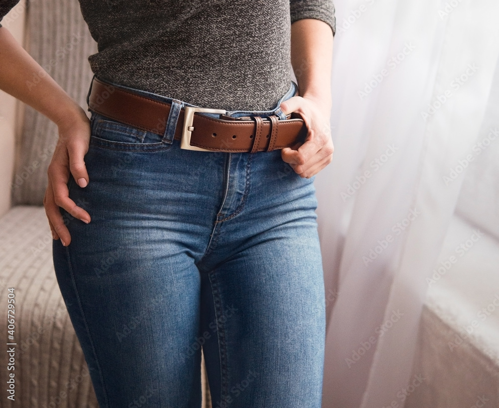Elegant, leather, brown belt on a belt with a metal buckle for a girl.  Original handmade leather clothing accessory Stock Photo | Adobe Stock