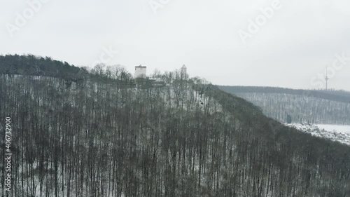 Drone aerial of the fairy tale castle Plesse in winter with a huge amount of snow on a beautiful mountain near Bovenden, Germany, Europe. photo