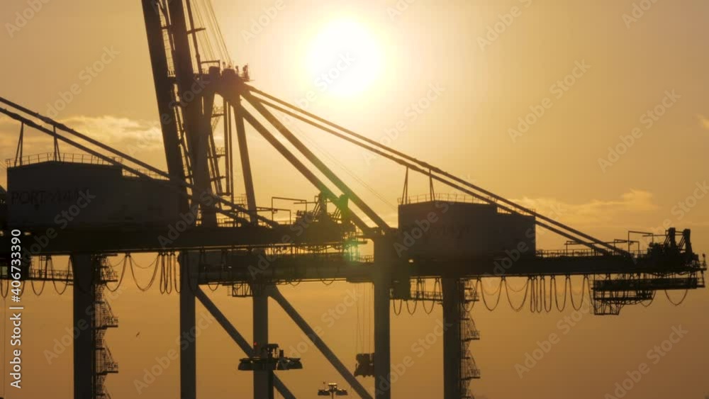 Gantry crane, or ship-to-shore crane, silhouetted by a golden Florida sunset in the Miami port. Gantry crane, or ship-to-shore crane, silhouetted by a golden Florida sunset in the Miami port.
