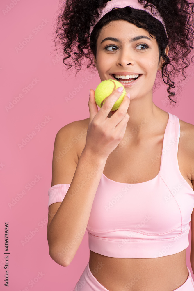 joyful young woman holding tennis ball isolated on pink joyful young woman holding tennis ball isolated on pink