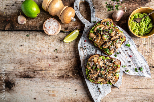 Bruschetta. Tasty sandwich with avocado  fried mushrooms  sesame on a wooden board. Healthy delicious breakfast or lunch. banner  catering menu recipe place for text  top view