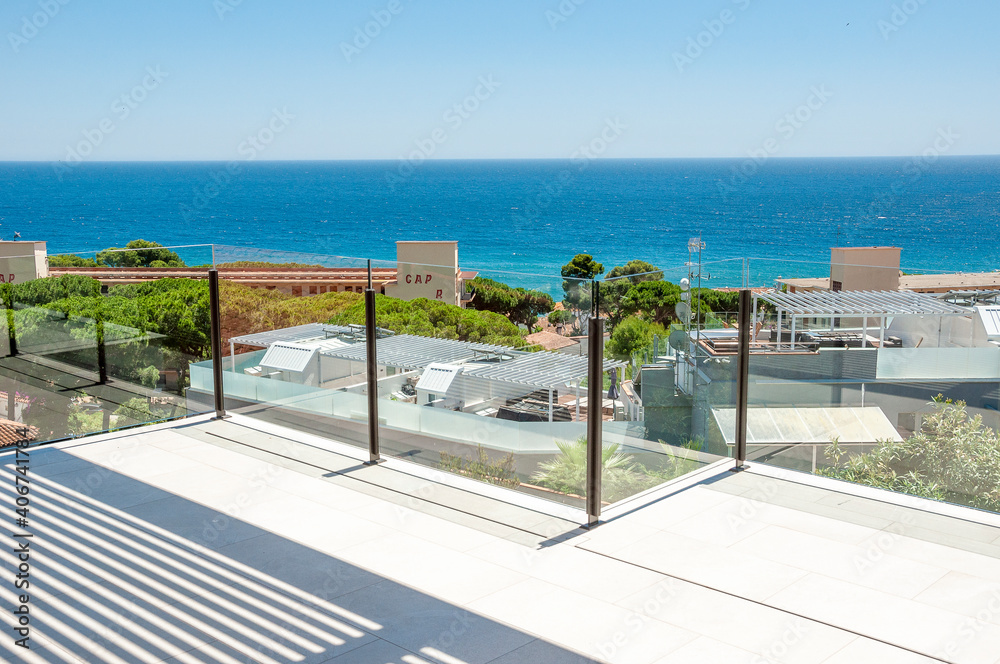 Sea view from a large terrace with a glass partition.