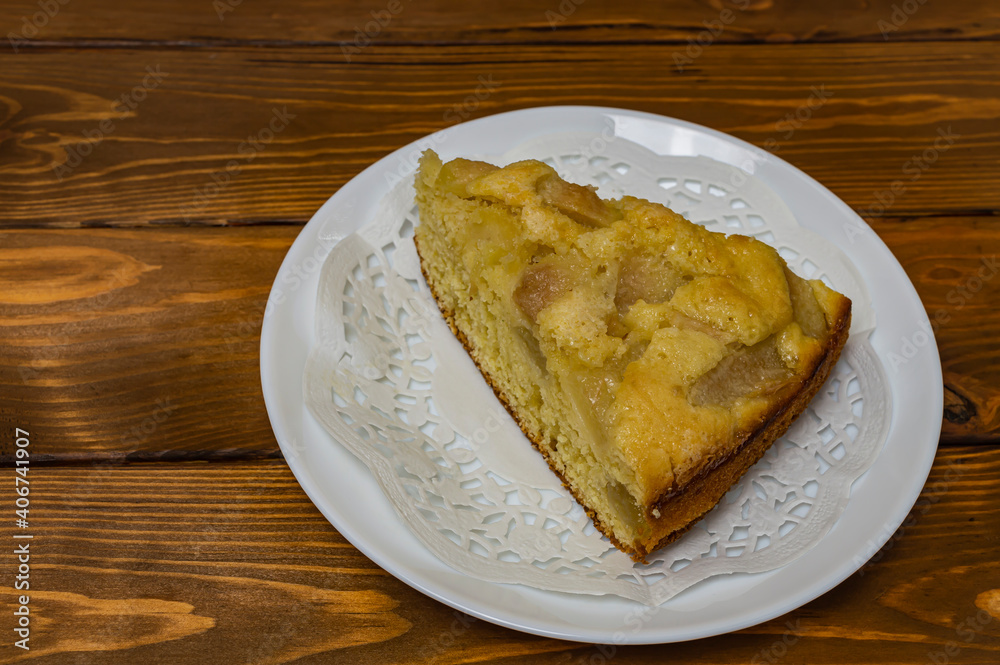 piece of pear pie on a white plate on a wooden table close-up