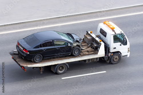 Konstfotografi Wrecked car after an accident on a tow truck transported on a highway