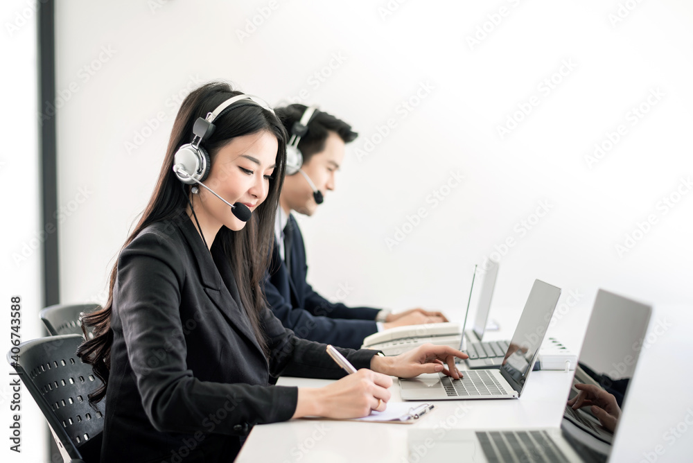 Asian employees work together in the call center in the office. Asian employees work together in the call center in the office.