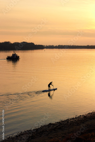 Top view of silhouette of man rowing on stand up paddle boards (SUP) on the river at sunset © watcherfox