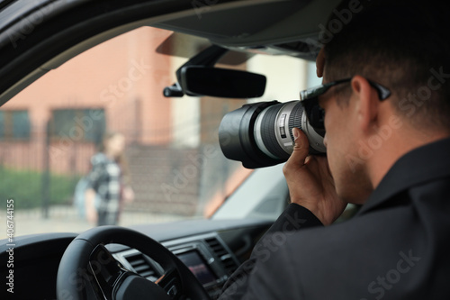 Private detective with camera spying from car © New Africa