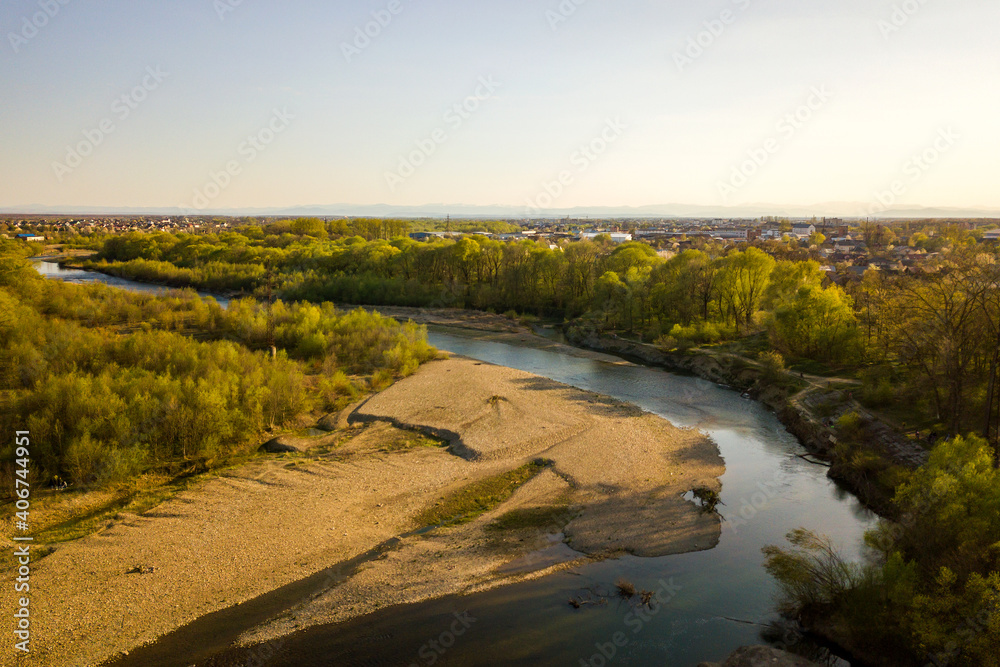 Aerial view of Ivano-Frankivsk city, Ukraine with Bystrytsia river and rural buildings in distance.