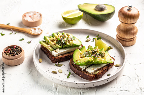 Tasty avocado sandwiches on table. The concept of eco products. Organic farm dairy products, cheeses, cereals. Vegan menu. Food recipe background. Close up