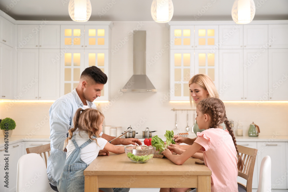 Happy family cooking together at table in modern kitchen Happy family cooking together at table in modern kitchen
