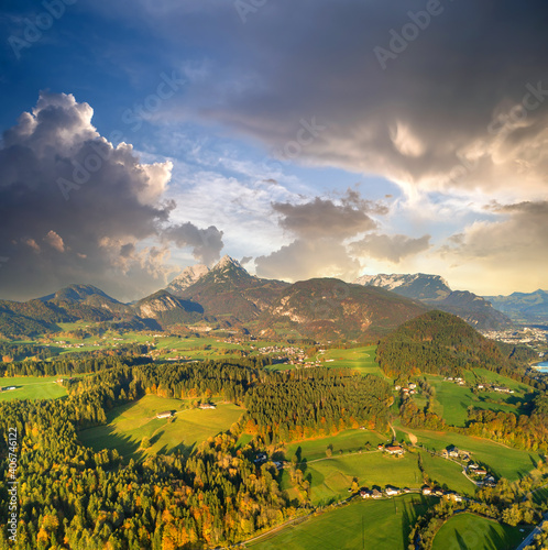 Aerial view of green meadows with villages and forest in austrian Alps mountains.