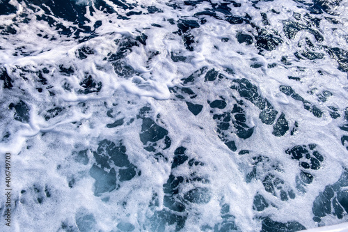 Top down aerial view of sea water surface. White foam waves texture as natural background. © bilanol