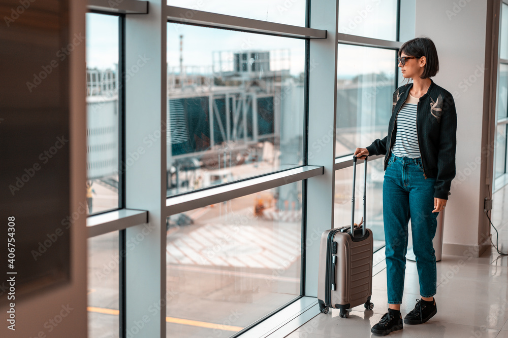 Woman on airport with bag waiting for plane Woman on airport with bag waiting for plane