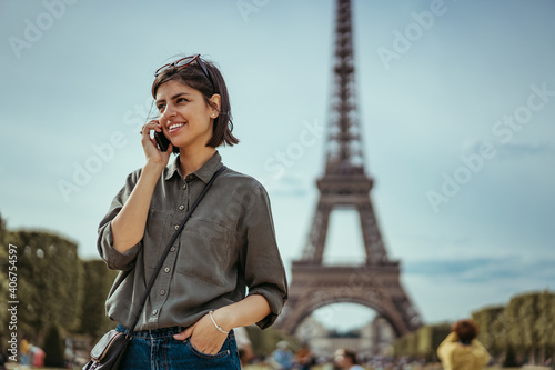Photography Young urban business woman talking on phone in Paris France next to Eiffel Tower