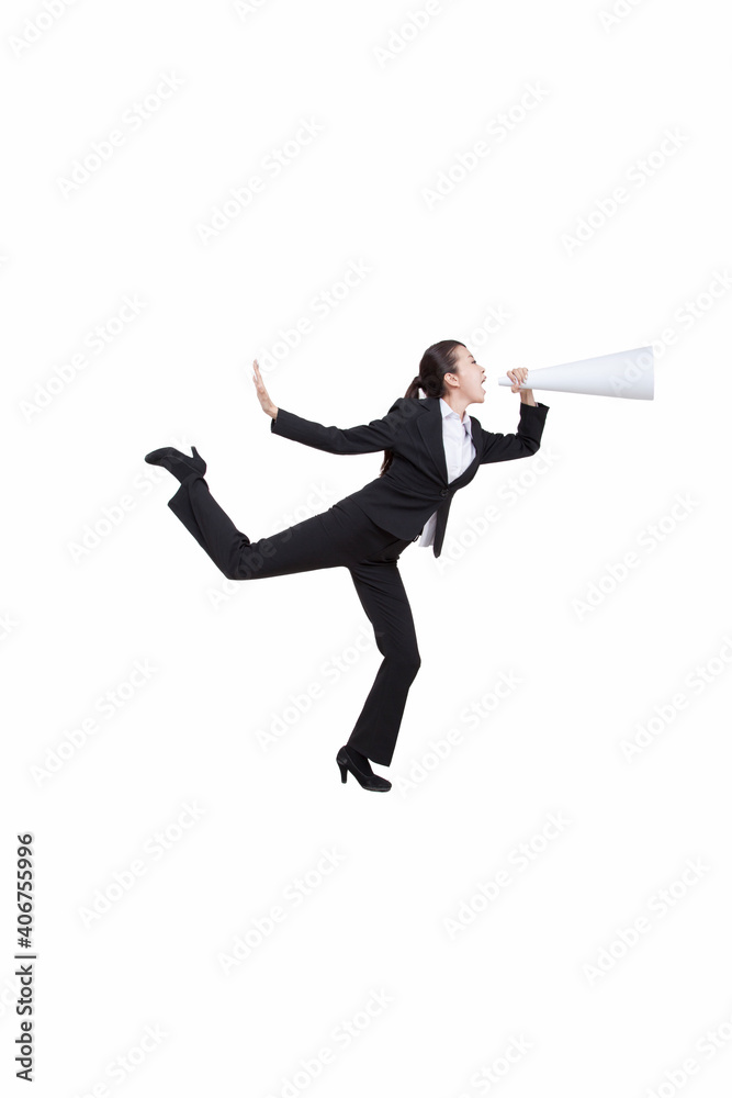 Portrait of young businesswoman shouting into megaphone