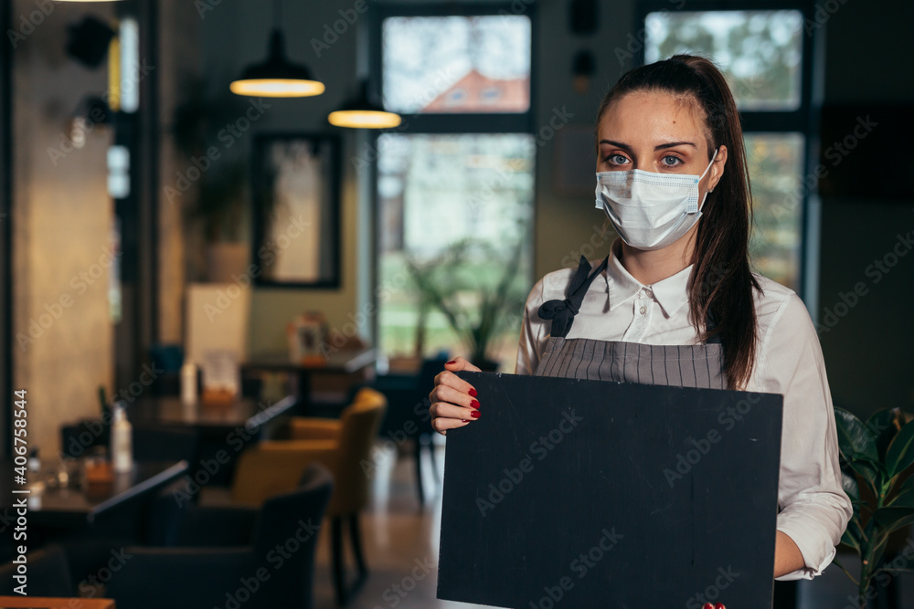 woman waitress holding blank sign board in restaurant. coronavirus concept