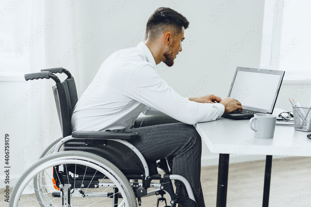Disabled man in a wheelchair using laptop Disabled man in a wheelchair using laptop