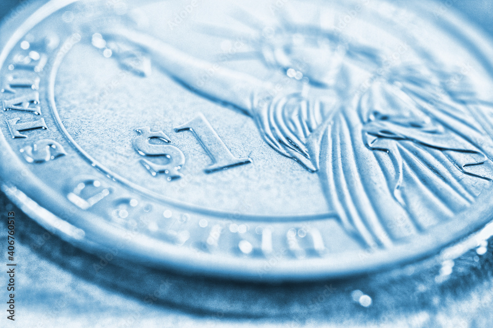 Fragment of an American 1 one dollar coin close-up. Light blue tinted  background on the