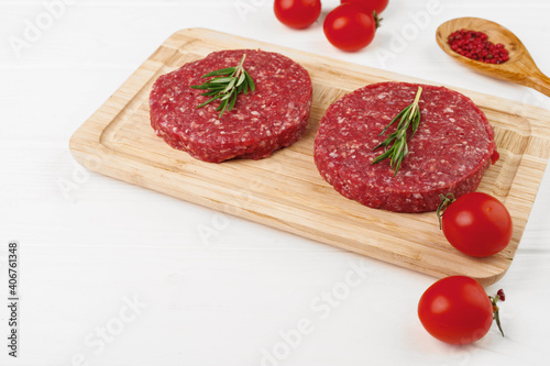 Two raw beef burger patties on wooden board © fotofabrika
