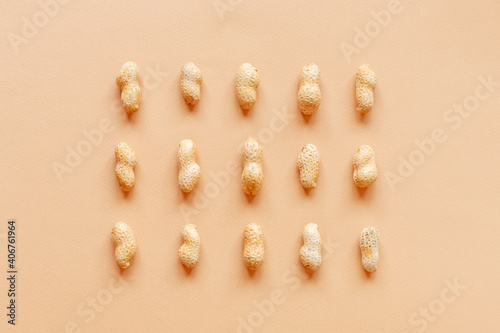 The texture with the walnuts on beige background. Peanuts in shells
