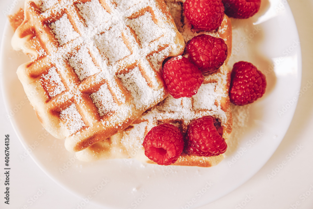Waffle with powdered sugar and raspberries Waffle with powdered sugar and raspberries