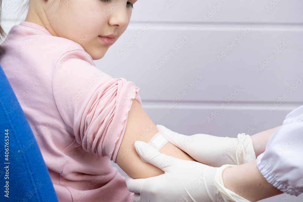 the child watches as the doctor applies plaster to the injection site the child watches as the doctor applies plaster to the injection site
