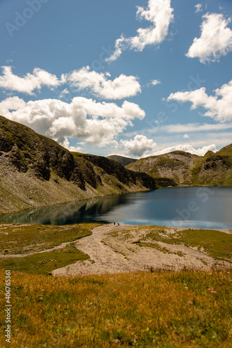 Fototapeta Naklejka Na Ścianę i Meble -  Fanealm und Wilder See in Suedtirol, Italy, Alpine pastures with a deep blue lake, green meadows and a blue sky with fleecy clouds, in summer