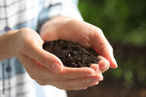 Woman with handful of soil outdoors, closeup