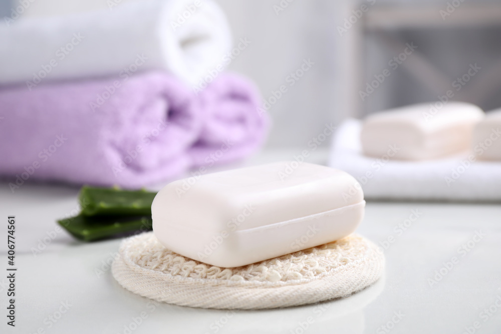 Soap bar and cloth on white table indoors Soap bar and cloth on white table indoors