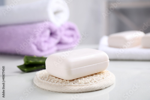 Soap bar and cloth on white table indoors