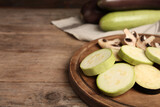 Slices of fresh zucchini and mushrooms on wooden table, closeup. Space for text
