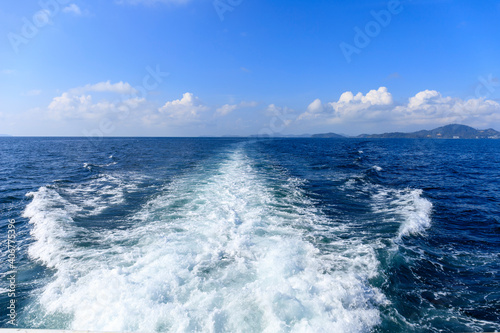 Boat wave ocean trace on blue sea fresh water background. Abstract sea water texture background. Travel destination motor boat water traces in open sea. © AKGK Studio