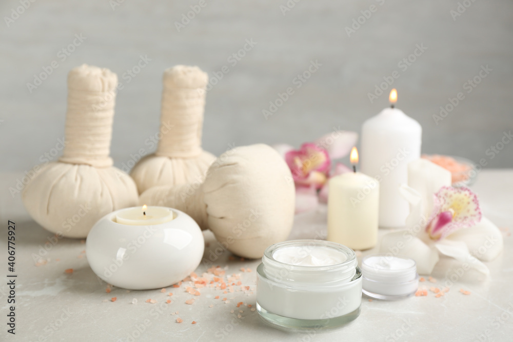 Beautiful spa composition with skin care products and candles on marble table Beautiful spa composition with skin care products and candles on marble table