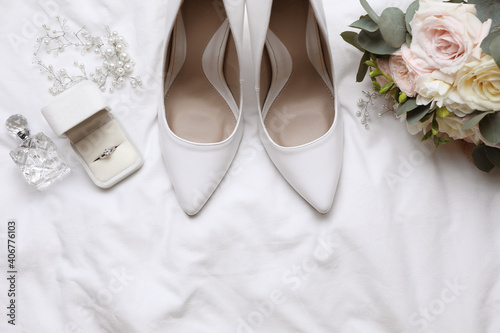 Flat lay composition with wedding high heel shoes on white fabric, space for text