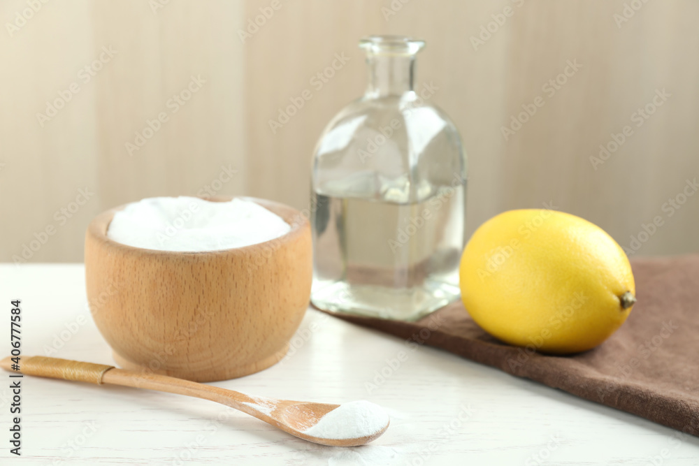 Baking soda, cut lemon and vinegar on white wooden table Baking soda, cut lemon and vinegar on white wooden table