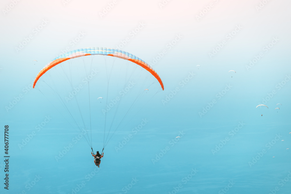 Group of paragliders flying in the blue sky. Extreme and air activity and sport concept. Blue sea at the background Group of paragliders flying in the blue sky. Extreme and air activity and sport concept. Blue sea at the background