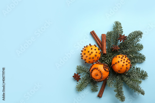 Flat lay composition with pomander balls made of fresh tangerines on light blue background. Space for text photo